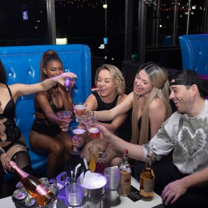 a group of people sitting at a table with a cake
